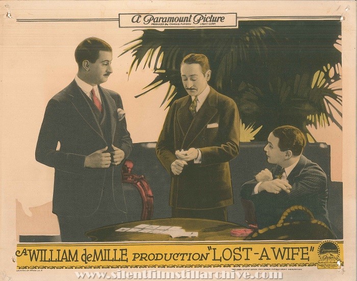 Lobby card with Adolphe Menjou and Robert Agnew in LOST - A WIFE (1928)