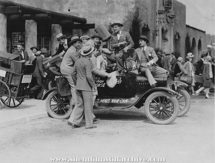 James Hall on the hood of the automobile in ROLLED STOCKINGS (1927).